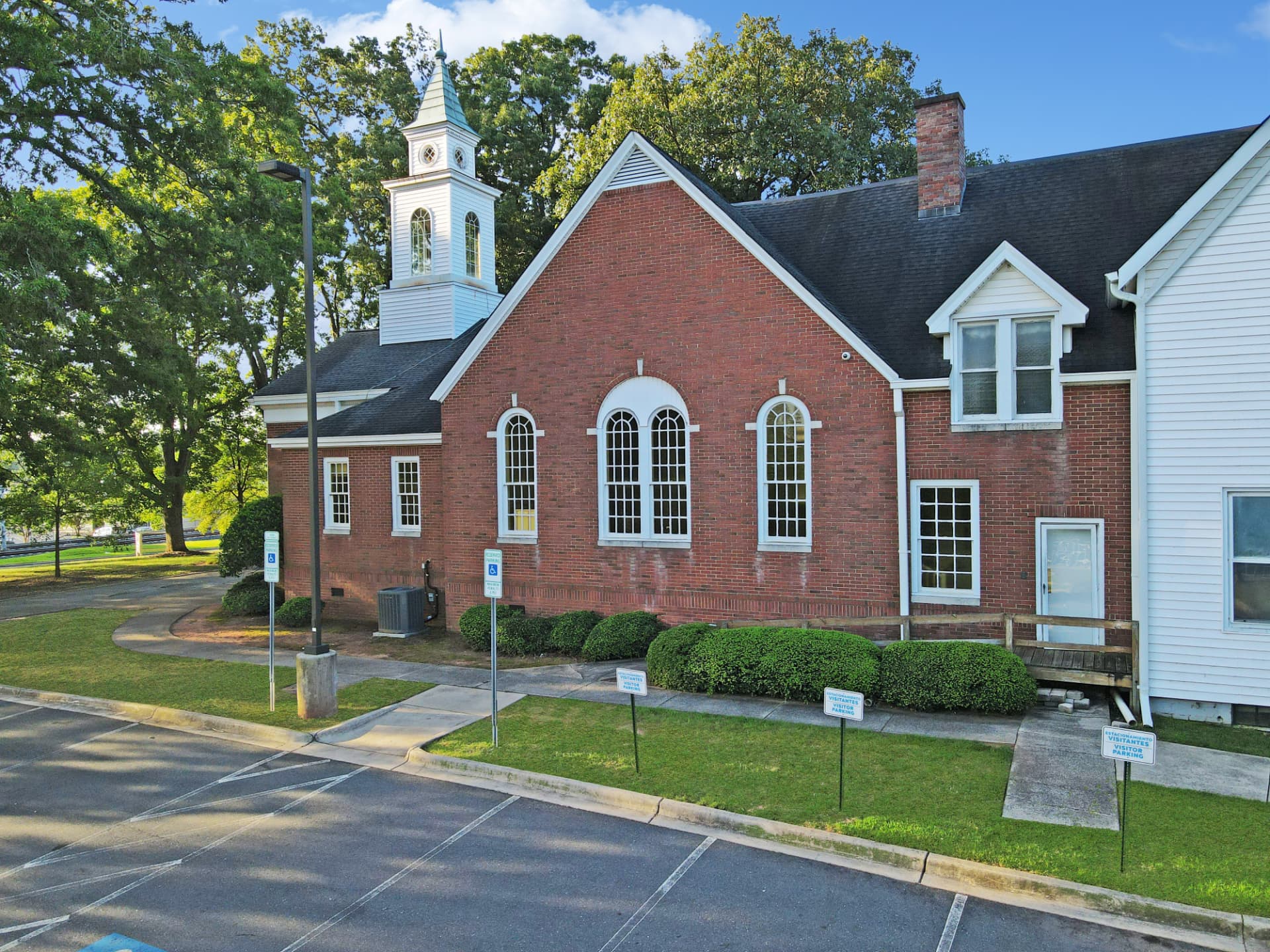 Side elevation of the chapel with arched windows and visitor parking