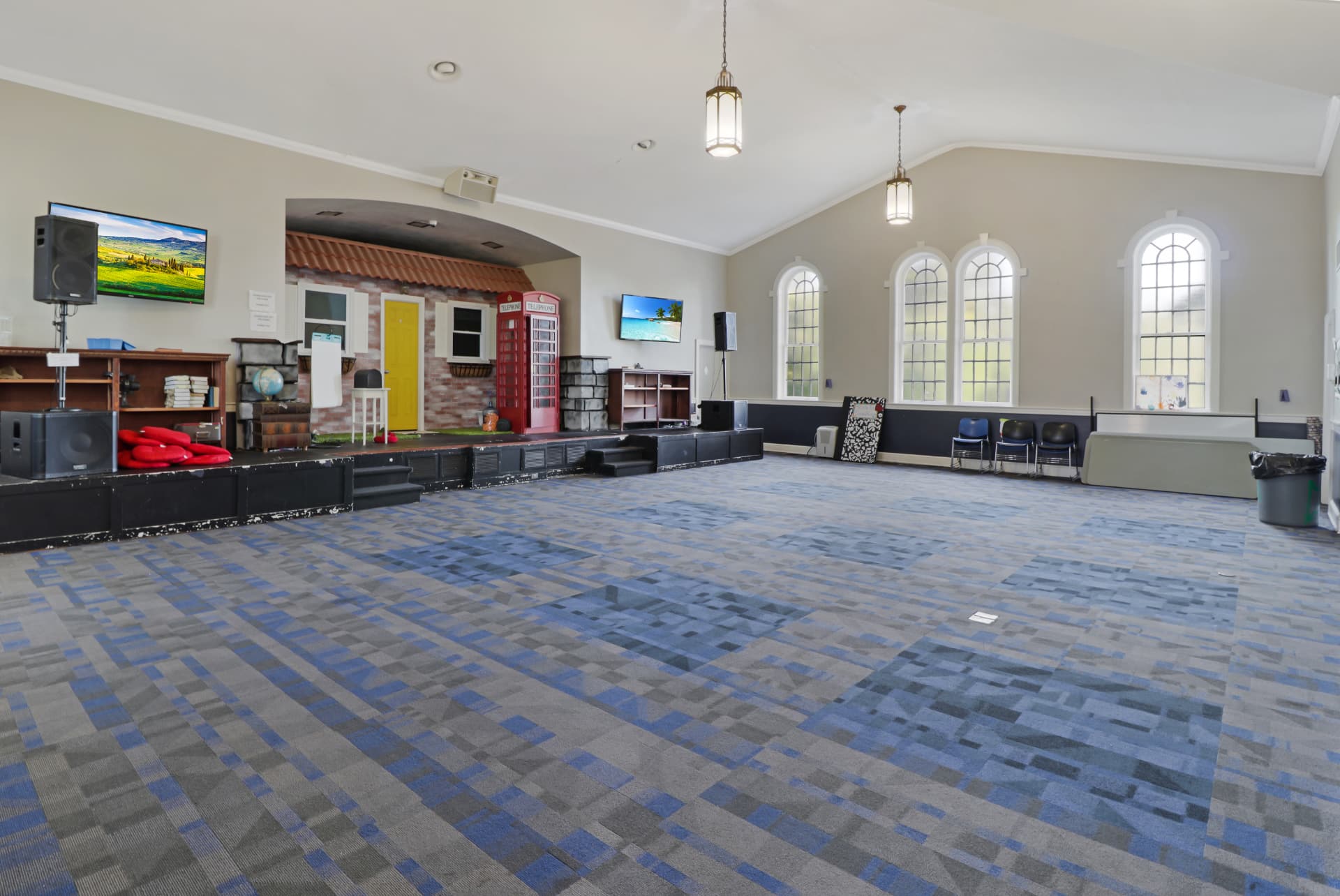 Open fellowship hall with arched windows and stage